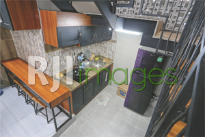 Dapur lantai bawah bernuansa industrial sebagai fasilitas bersama