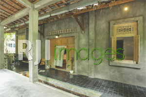 Teras depan bergaya klasik dengan dinding ekspos & unsur kayu